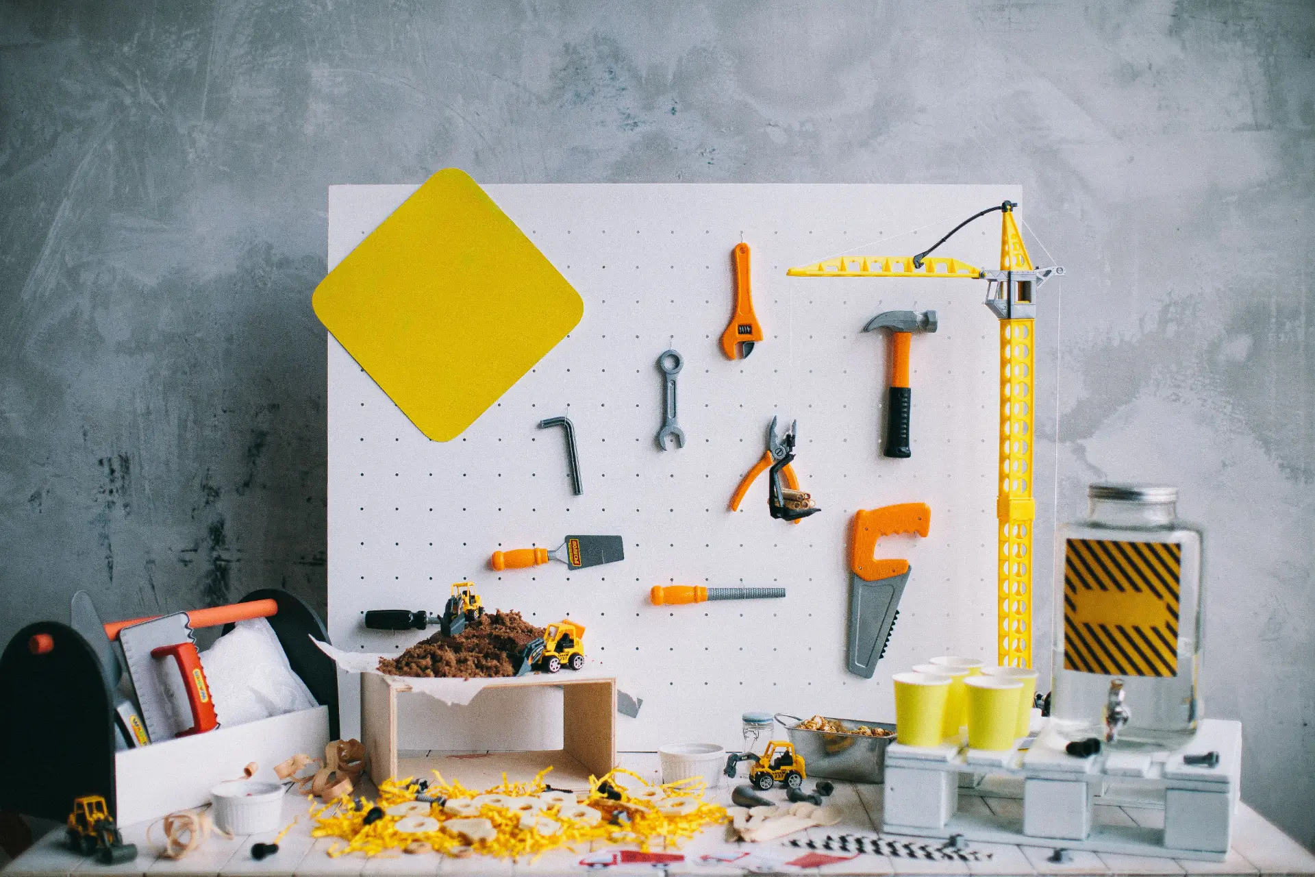 Art department tools and miniature construction equipment arranged on a workbench